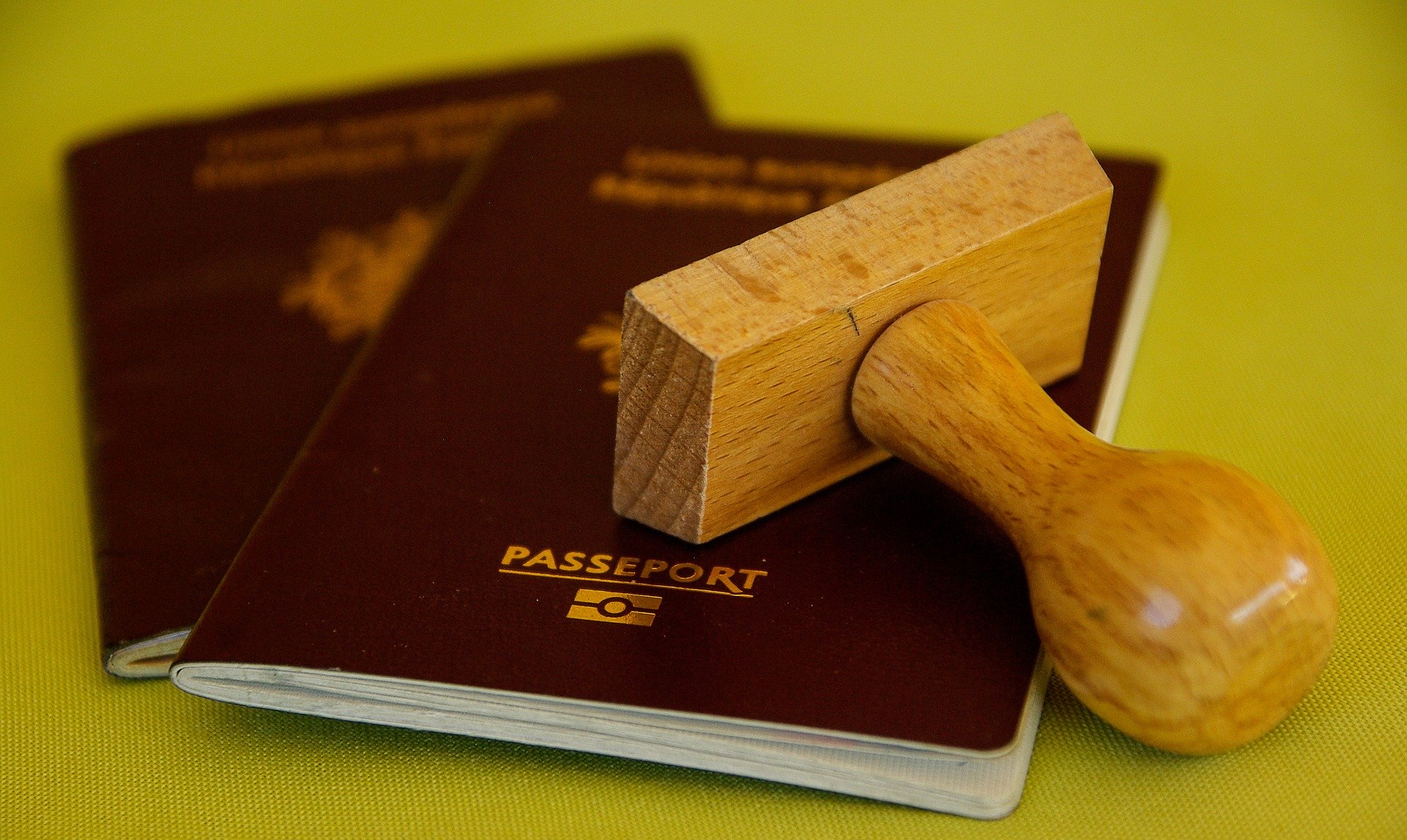 An image showing old style UK EU passports and a stamp tool: convenient passport services